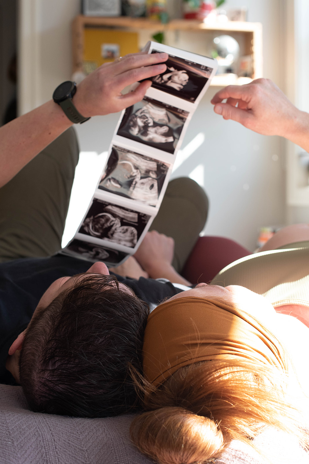 an lgbtq couple looks at their sonogram photos during a maternity photography session in Chicago